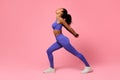 black woman in fitwear performing backbend in lunge position, studio Royalty Free Stock Photo