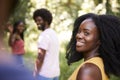 Young black woman in a forest with friends turning to camera Royalty Free Stock Photo