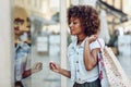 Young black woman, afro hairstyle, looking at a shop window Royalty Free Stock Photo