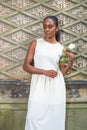 Young black woman holding white rose, standing outdoors in New York City,, thinking Royalty Free Stock Photo