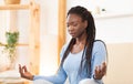 Young Black Woman Meditating In Lotus Position In Bed Indoor