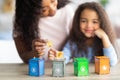 Young black woman playing sorting gabrage board game with her daughter at home, selective focus. Copy space Royalty Free Stock Photo