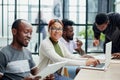 young black woman posing for the camera while sitting at the table in front of her colleagues Royalty Free Stock Photo