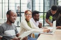 young black woman posing for the camera while sitting at the table in front of her colleagues Royalty Free Stock Photo