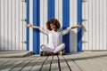 Young black woman on roller skates sitting near a beach hut. Royalty Free Stock Photo
