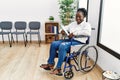 Young black woman sitting on wheelchair at waiting room with a happy and cool smile on face Royalty Free Stock Photo