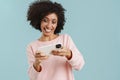 Young black woman smiling and playing online game on cellphone Royalty Free Stock Photo