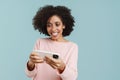 Young black woman smiling and playing online game on cellphone Royalty Free Stock Photo