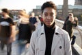 Young black woman standing on Millennium Bridge, London, looking to camera while pedestrians pass by, motion blur Royalty Free Stock Photo