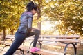 Young black woman stretching on a bench in a Brooklyn park