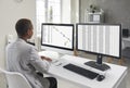 Financial accountant sitting at office desk and working on two desktop computers Royalty Free Stock Photo