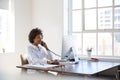 Young black woman talking on phone at her desk in an office Royalty Free Stock Photo