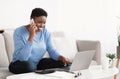 Young black woman talking on smartphone using laptop Royalty Free Stock Photo