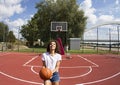 A young black woman.She tries to throw the ball.Backwards towards the basket board.Serbia.Novi Sad.
