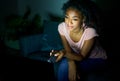 Young black woman watching tv late at night