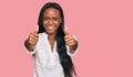 Young black woman wearing casual clothes approving doing positive gesture with hand, thumbs up smiling and happy for success Royalty Free Stock Photo