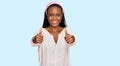 Young black woman wearing casual clothes approving doing positive gesture with hand, thumbs up smiling and happy for success Royalty Free Stock Photo