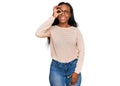 Young black woman wearing casual clothes and glasses smiling happy doing ok sign with hand on eye looking through fingers Royalty Free Stock Photo