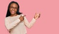 Young black woman wearing casual clothes and glasses smiling and looking at the camera pointing with two hands and fingers to the Royalty Free Stock Photo
