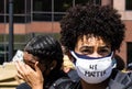 A Young Black Woman Wears a Mask With the Words `We Matter` Written on It