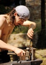 Young blacksmith hammering hot iron Royalty Free Stock Photo