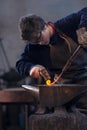 Young blacksmith working with red hot metal Royalty Free Stock Photo