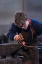 Young blacksmith working with red hot metal Royalty Free Stock Photo