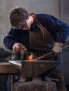 Young blacksmith working with red hot metal Royalty Free Stock Photo