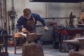 Young blacksmith working with red hot metal