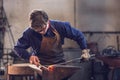 Young blacksmith working with red hot metal Royalty Free Stock Photo