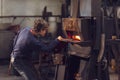 Young blaksmith working in a metalworking workshop