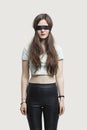 Young blindfolded woman standing against gray background