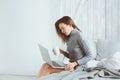 Young blogger or business woman working at home with social media, drinking coffee in early morning in bed Royalty Free Stock Photo