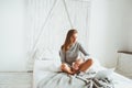 Young blogger or business woman working at home with social media, drinking coffee in early morning in bed Royalty Free Stock Photo