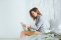 Young blogger or business woman working at home with social media, drinking coffee in early morning in bed