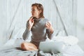 Young blogger or business woman working at home with social media, drinking coffee in early morning in bed