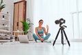 Young blogger with camera on tripod recording online fitness class in home Royalty Free Stock Photo