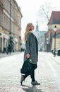 Young blond beautiful woman walking on city street in Krakow. sunny weather