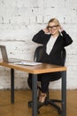 Young blond beauty businesswoman sitting at a office table with laptop, notebook and glasses in suit. Business concept. Royalty Free Stock Photo