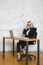 Young blond beauty businesswoman sitting at a office table with laptop, notebook and glasses in suit. Business concept. Royalty Free Stock Photo