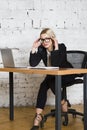 Young blond beauty businesswoman sitting at a office table with laptop, notebook and glasses in suit. Business concept. Royalty Free Stock Photo