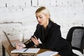 Young blond beauty businesswoman sitting at a office table with laptop, notebook and glasses in suit. Business concept. Royalty Free Stock Photo