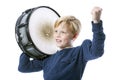 Young blond boy with drum against white background shows muscle