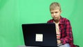 Teenager with a laptop on a green background.