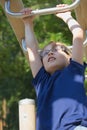 Young blond boy is playing at monkey bars. Royalty Free Stock Photo