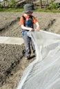 Young blond boy plowing and raking and preparing his vegetable plot in a garden Royalty Free Stock Photo