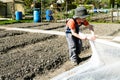 Young blond boy plowing and raking and preparing his vegetable plot in a garden Royalty Free Stock Photo