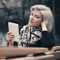 Young fashion blond business woman using tablet computer in city street Royalty Free Stock Photo