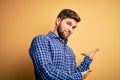 Young blond businessman with beard and blue eyes wearing shirt over yellow background Inviting to enter smiling natural with open Royalty Free Stock Photo