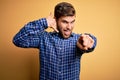 Young blond businessman with beard and blue eyes wearing shirt over yellow background smiling doing talking on the telephone Royalty Free Stock Photo